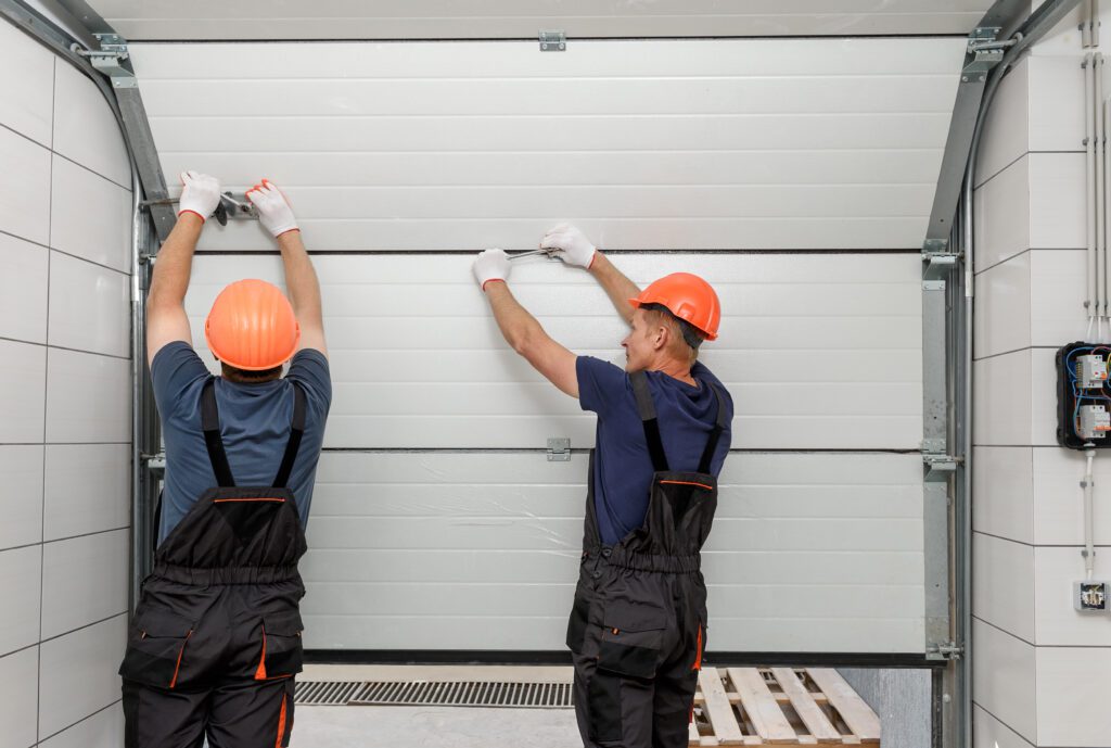 Workers from patrick sprack limited are installing lifting gates of the garage door as part of the preventive maintenance program